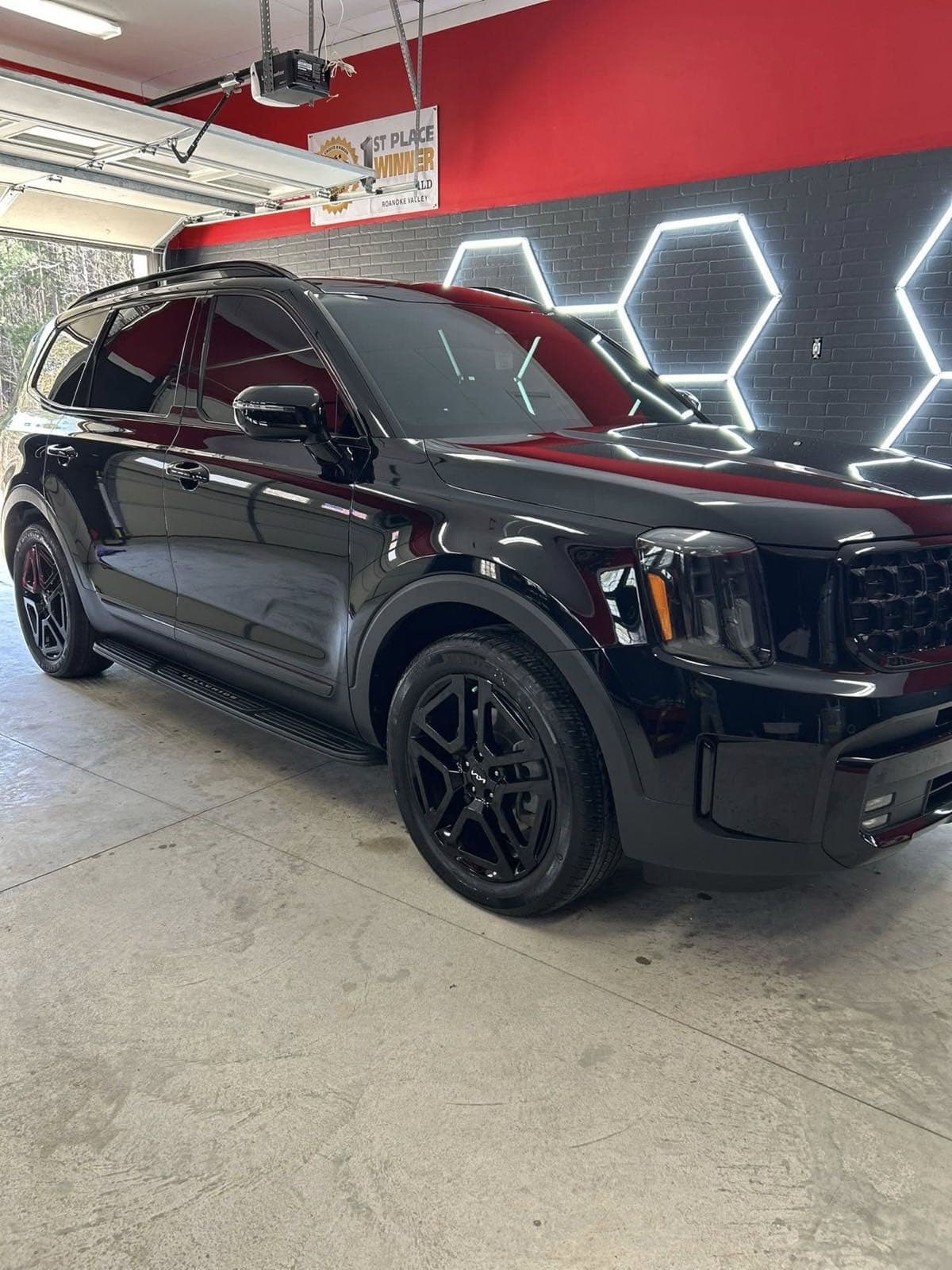 Black Kia Telluride freshly detailed in the detail bay with hex lights
