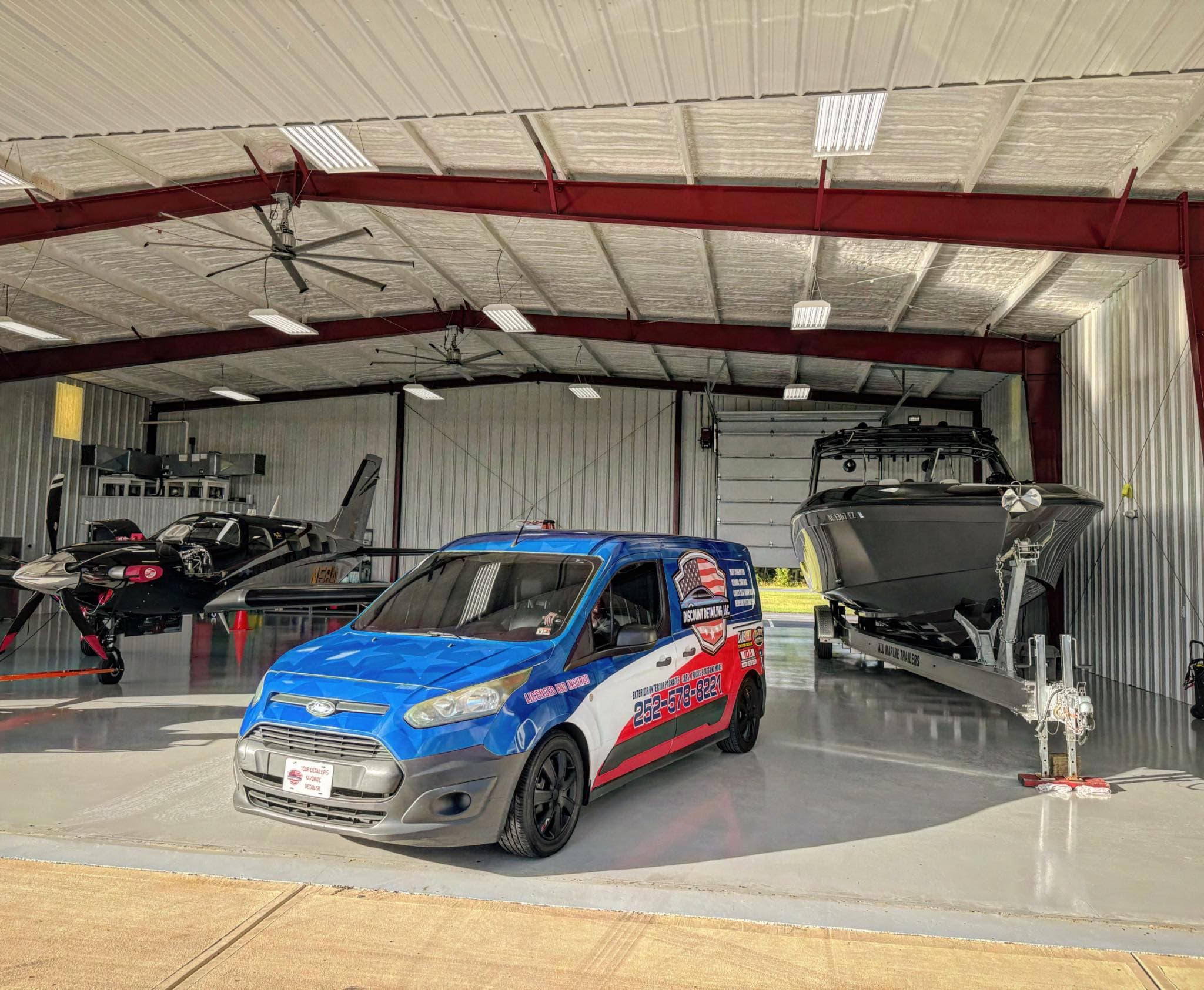 Discount Detailing branded van in front of a boat and aircraft hangar